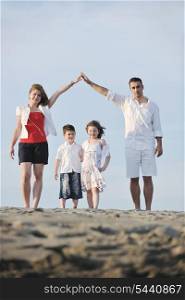 happy young family have fun on beachand showing home sign with conncected hands while protecting childrens