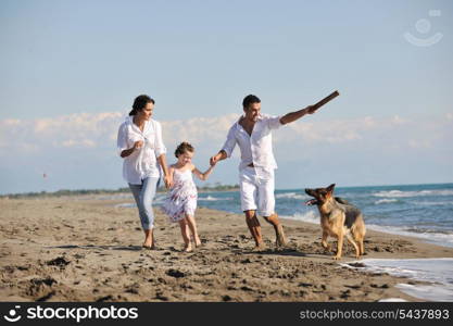 happy young family in white clothing have fun and play with beautiful dog at vacations on beautiful beach