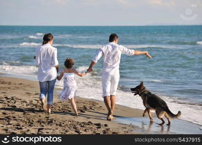 happy young family in white clothing have fun and play with beautiful dog at vacations on beautiful beach