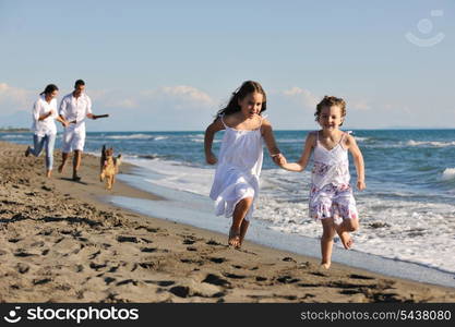 happy young family in white clothing have fun and play with beautiful dog at vacations on beautiful beach