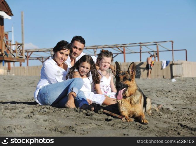 happy young family in white clothing have fun and play with beautiful dog at vacations on beautiful beach