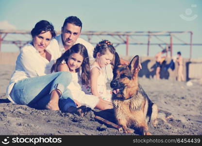 happy young family in white clothing have fun and play with beautiful dog at vacations on beautiful beach