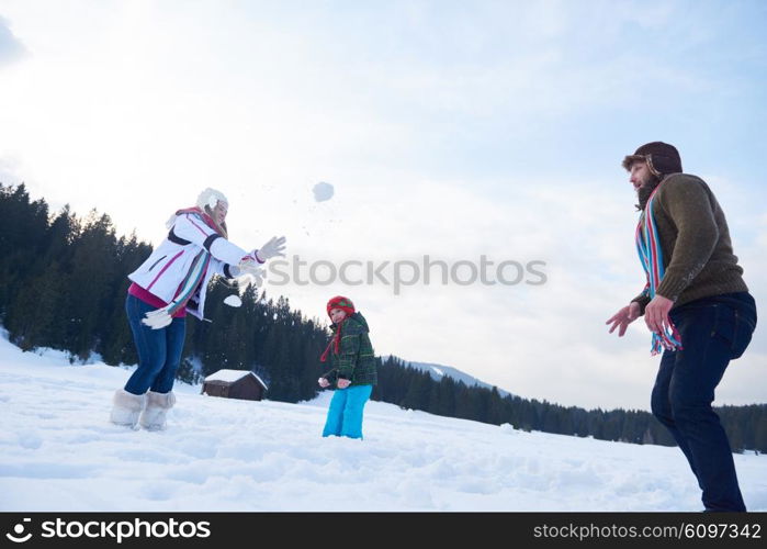 happy young family playing in fresh snow at beautiful sunny winter day outdoor in nature