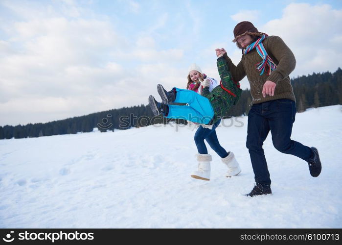 happy young family playing in fresh snow at beautiful sunny winter day outdoor in nature