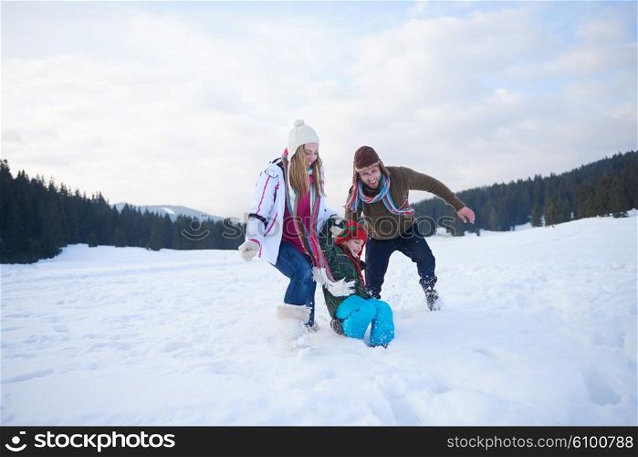 happy young family playing in fresh snow at beautiful sunny winter day outdoor in nature