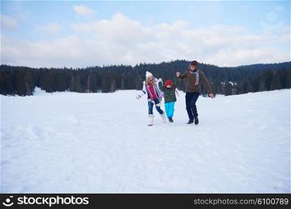 happy young family playing in fresh snow at beautiful sunny winter day outdoor in nature