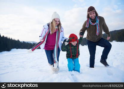 happy young family playing in fresh snow at beautiful sunny winter day outdoor in nature