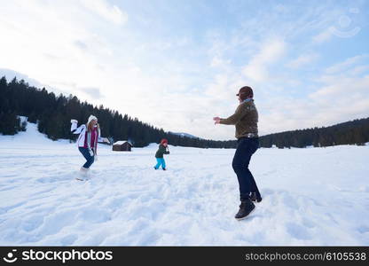 happy young family playing in fresh snow at beautiful sunny winter day outdoor in nature