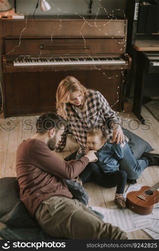 Happy young family playing on the floor  in the room