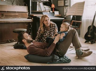 Happy young family playing on the floor  in the room
