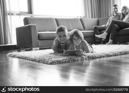 Happy Young Family Playing Together at home.kids using tablet on the floor