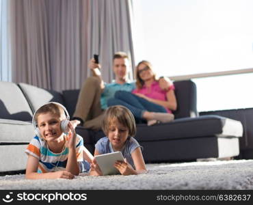 Happy Young Family Playing Together at home.kids using tablet on the floor