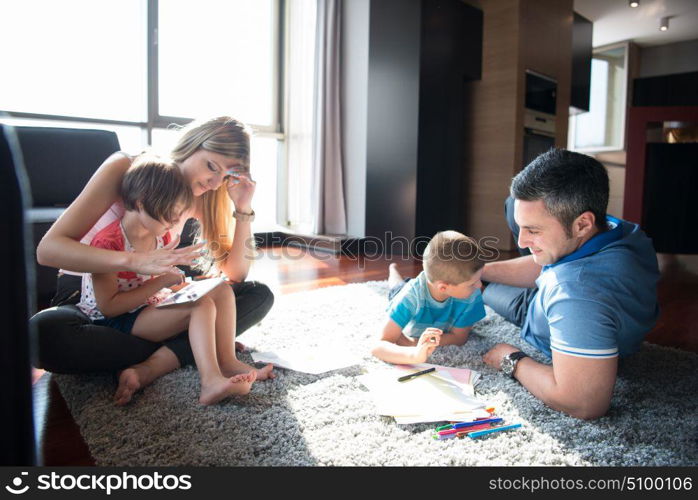 Happy Young Family Playing Together at home on the floor using a tablet and a children&rsquo;s drawing set