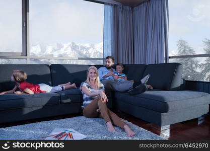 Happy Young Family Playing Together at home on the floor using a tablet and a children&rsquo;s drawing set