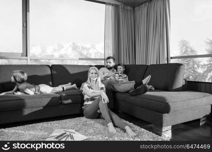 Happy Young Family Playing Together at home on the floor using a tablet and a children&rsquo;s drawing set. young couple spending time with kids