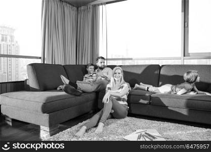 Happy Young Family Playing Together at home on the floor using a tablet and a children&rsquo;s drawing set. young couple spending time with kids