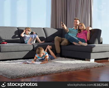 Happy Young Family Playing Together at home using a tablet and a children&rsquo;s drawing set