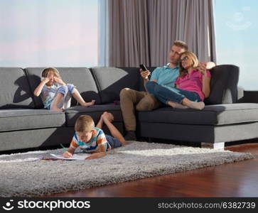 Happy Young Family Playing Together at home using a tablet and a children&rsquo;s drawing set