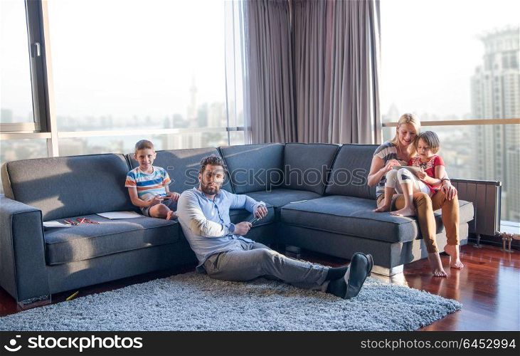 Happy Young Family Playing Together on sofa at home using a tablet and a children&rsquo;s drawing set