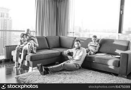 Happy Young Family Playing Together on sofa at home using a tablet and a children&rsquo;s drawing set. Happy Young Family Playing Together on sofa