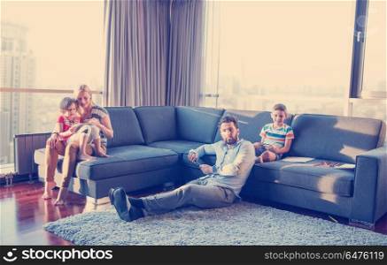 Happy Young Family Playing Together on sofa at home using a tablet and a children&rsquo;s drawing set. Happy Young Family Playing Together on sofa