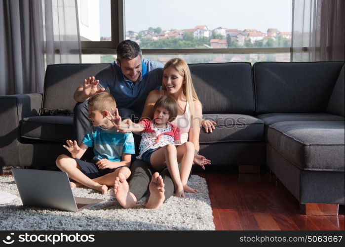 Happy Young Family Playing Together with laptop computer at home sitting on the sofa