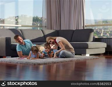 Happy Young Family Playing Together with tablet at home sitting on the floor