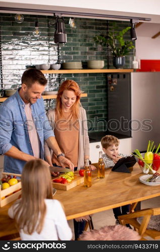 Happy young family preparing vegetables in the kitchen