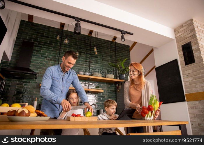 Happy young family preparing vegetables in the kitchen