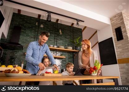 Happy young family preparing vegetables in the kitchen