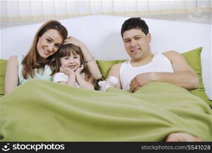 happy young family relaxing in bed