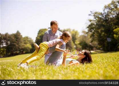 Happy young family with cute litt≤daughter having fun in park on a sunny day
