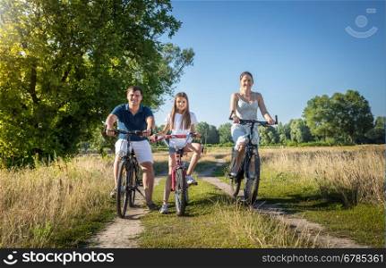 Happy young family with daughter having weekend on their bicycles