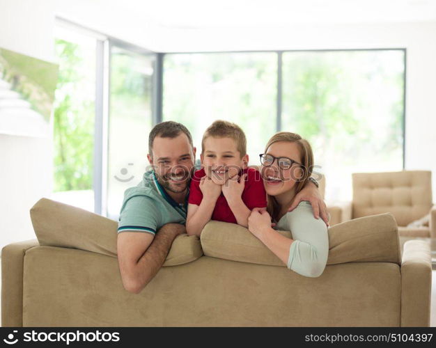 happy young family with little boy enjoys in the modern living room of their luxury home villa