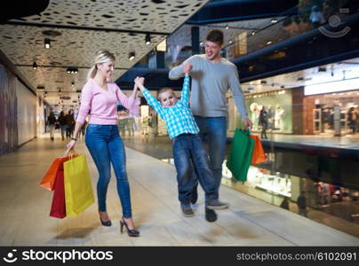 happy young family with shopping bags in mall