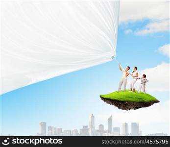 Happy young family. Young family of three pulling blank banner. Place for text