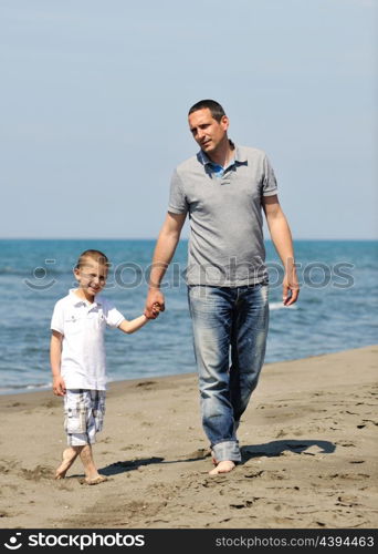 happy young father and son have fun and enjoy time on beach at sunset and representing healthy family and support concept