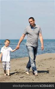 happy young father and son have fun and enjoy time on beach at sunset and representing healthy family and support concept