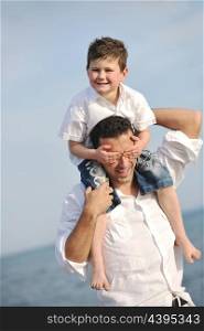 happy young father and son have fun and enjoy time on beach at sunset and representing healthy family and support concept