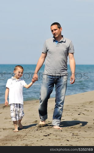 happy young father and son have fun and enjoy time on beach at sunset and representing healthy family and support concept