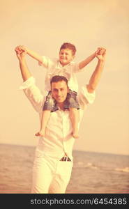 happy young father and son have fun and enjoy time on beach at sunset and representing healthy family and support concept