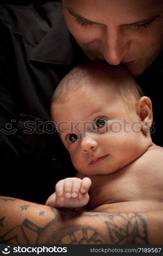 Happy Young Father Holding His Mixed Race Newborn Baby Under Dramatic Lighting.