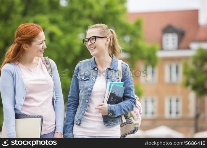 Happy young female college friends walking outdoors