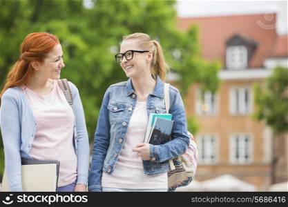 Happy young female college friends walking outdoors