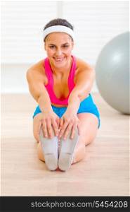 Happy young female doing exercises on floor at living room&#xA;