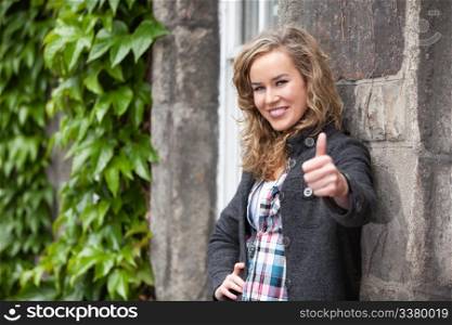 Happy young female smiling and showing thumb