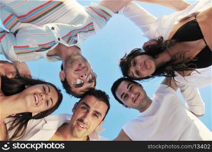 happy young friends group team huging have fun and celebrate on the beach at the sunset