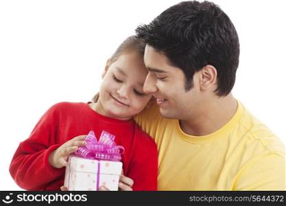 Happy young girl and her father looking at gift