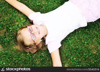 happy young girl children relax lie and have fun on grass with flower