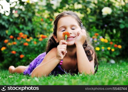 happy young girl children relax lie and have fun on grass with flower